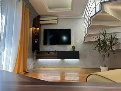 a living room with a tv on a wall at Royal suite Nis in Niš
