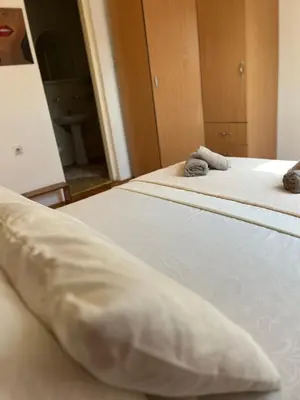 two beds with white pillows in a room at Royal suite Nis in Niš