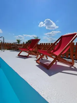 two red lounge chairs next to a swimming pool at Vikendica sa bazenom Čarolija Kruševac in Kruševac