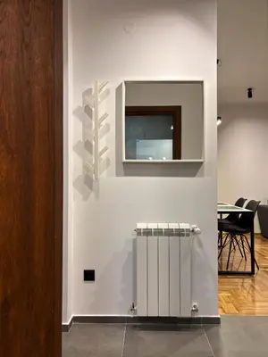 a white wall with a television and a table at Apartman Grey LUX in Pirot