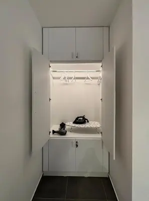 a walk in closet with white cabinets and a telephone at Apartman Grey LUX in Pirot