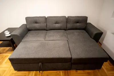 a gray couch in a living room with a table at Apartman Grey LUX in Pirot