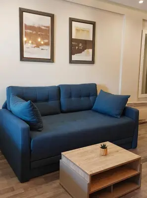 a blue couch in a living room with a coffee table at Apartman Viva Milmari in Kopaonik