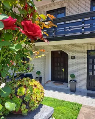 a building with a flower bush in front of it at Vila Jevtić studio 1 in Soko Banja