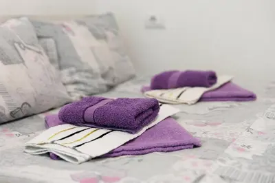 a group of purple towels sitting on a bed at Vila Jevtić studio 1 in Soko Banja