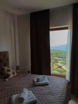 a bedroom with a bed with towels and a window at Milmari resort N12 in Kopaonik