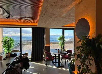 a living room with a table and chairs and windows at Milmari resort N12 in Kopaonik