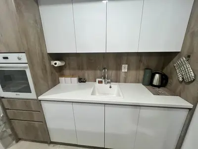 a kitchen with white cabinets and a sink at Apartman Kraljice Natalije in Vrnjačka Banja