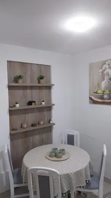 a dining room with a table and chairs and a shelf at Apartman Kraljice Natalije in Vrnjačka Banja