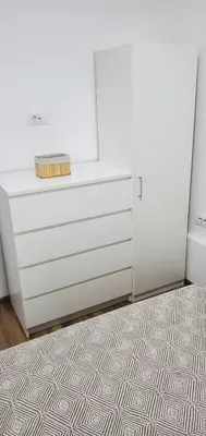 a white dresser in a room with a rug at Apartman Kraljice Natalije in Vrnjačka Banja
