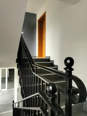 a staircase with black railings and a wooden door at Trajkovic One Bedroom Apartment in Soko Banja