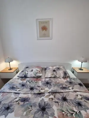 a bedroom with a bed with a floral bedspread at Marlux 2 in Pirot