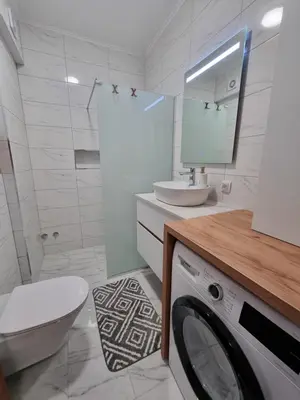 a bathroom with a washing machine and a sink at Marlux 2 in Pirot