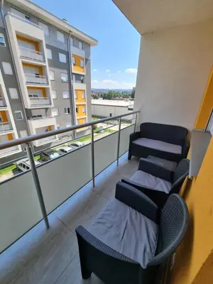 a balcony with chairs and tables on a building at Marlux 2 in Pirot