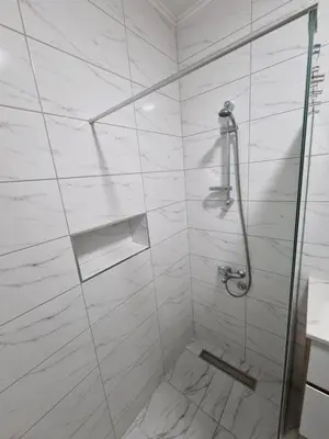 a white bathroom with a shower with a toilet at Marlux 2 in Pirot