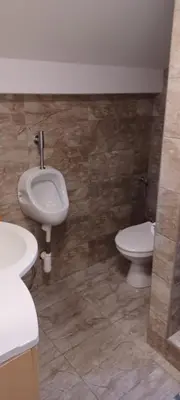 a bathroom with a toilet and a sink and a urinal at Vikendica Sofia in Žagubica