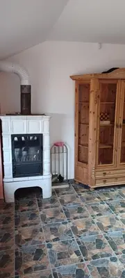 a living room with a fireplace and wooden cabinets at Vikendica Sofia in Žagubica