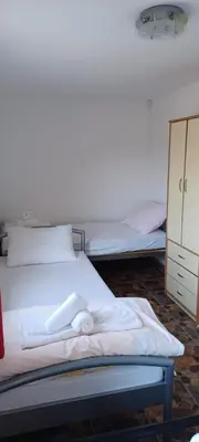 a bedroom with two beds and a dresser at Vikendica Sofia in Žagubica