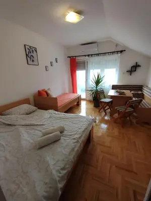 a bedroom with a bed and a living room at Latinski apartman in Soko Banja