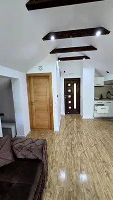 a living room with a couch and a kitchen at Vila Dolina Mira in Zabrega