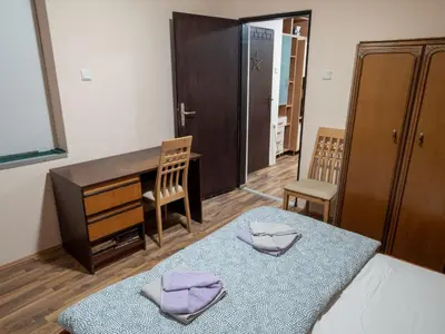 a bedroom with a bed and a desk with two towels at Apartman Aleksandar in Kruševac