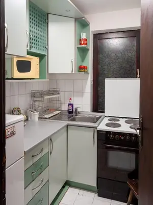 a kitchen with green and white cabinets and a sink at Apartman Aleksandar in Kruševac