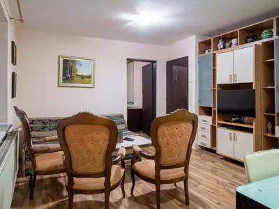 a living room with chairs and a table and a television at Apartman Aleksandar in Kruševac