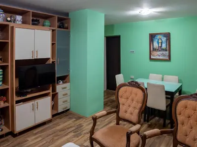 a living room with blue walls and a dining room at Apartman Aleksandar in Kruševac