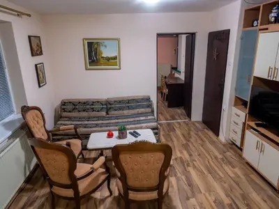 a living room with a couch and a table and chairs at Apartman Aleksandar in Kruševac