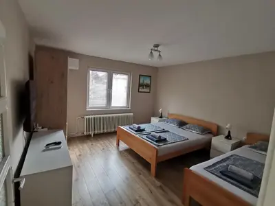 a large room with two beds and a table at Apartman Meridian in Zaječar