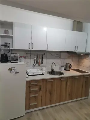 a kitchen with white cabinets and a sink at Apartman Meridian in Zaječar
