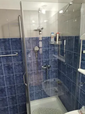 a bathroom with a shower with blue tile at Apartman Meridian in Zaječar