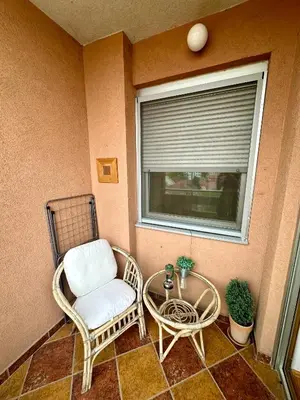 a balcony with a chair and a table and a window at PLANIS apartments in Niš