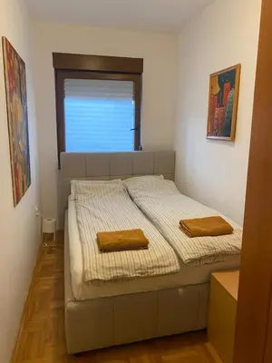 a bedroom with a bed with two pillows on it at PLANIS apartments in Niš
