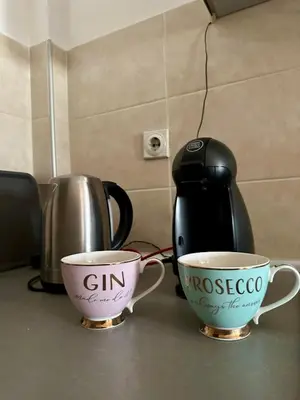 two cups of coffee on a counter with a coffee pot at PLANIS apartments in Niš