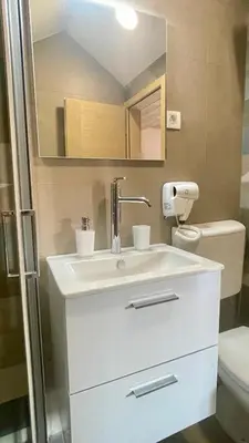 a bathroom with a sink and a toilet at Amigos Suits in Niš