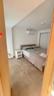 a bedroom with a bed and a night stand at Amigos Suits in Niš