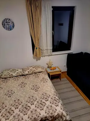 a bedroom with a bed and a window and a table at Kopaonik apartman 11 in Kopaonik