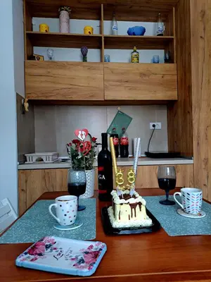 a table with a cake and a bottle of wine at Kopaonik apartman 11 in Kopaonik