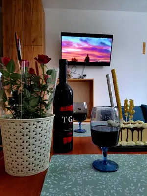 a bottle of wine and two glasses on a table at Kopaonik apartman 11 in Kopaonik