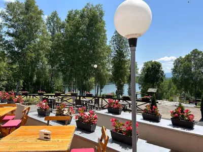 a patio with tables and chairs and a street light at Hotel Vlasina - Vlasinsko jezero in Lujinska Mala