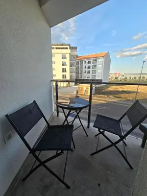 a patio with two chairs and a table on a balcony at Apartmani Krunet in Kruševac
