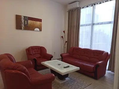 a living room with two red chairs and a table at Apartman Milutinovic in Vranje