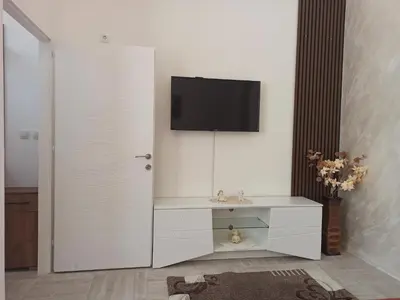 a white cabinet with a tv on a wall at Apartman Milutinovic in Vranje