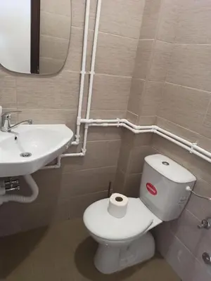 a bathroom with a white toilet and a sink at Apartman Milutinovic in Vranje