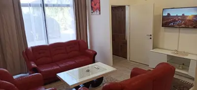 a living room with a red couch and a tv at Apartman Milutinovic in Vranje