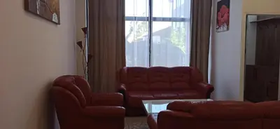 a living room with two chairs and a couch and a window at Apartman Milutinovic in Vranje