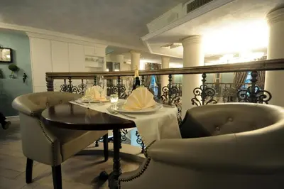 a dining room with a table and a chair at Luxury Rooms Minjon in Vrnjačka Banja