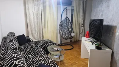 a living room with a couch and a table with a lamp at JM Apartman in Donja Vrežina