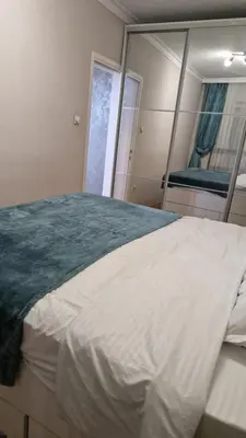 a bedroom with a large bed and a mirror at JM Apartman in Donja Vrežina